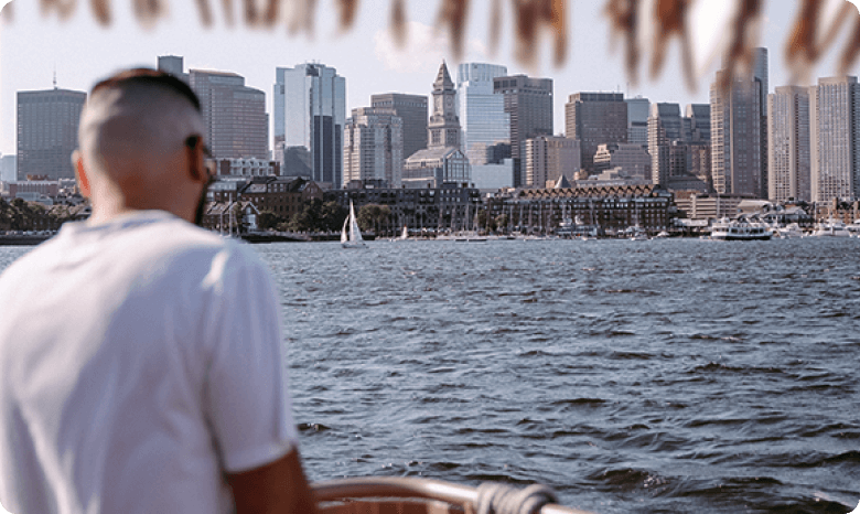 a guy enjoying the city view of Boston on Corporate Boat Cruise